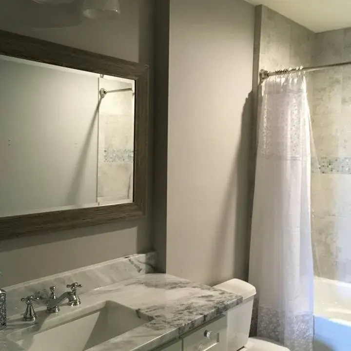 Vanity and mirror beside a curtained tub, C&A Roofing & Construction
