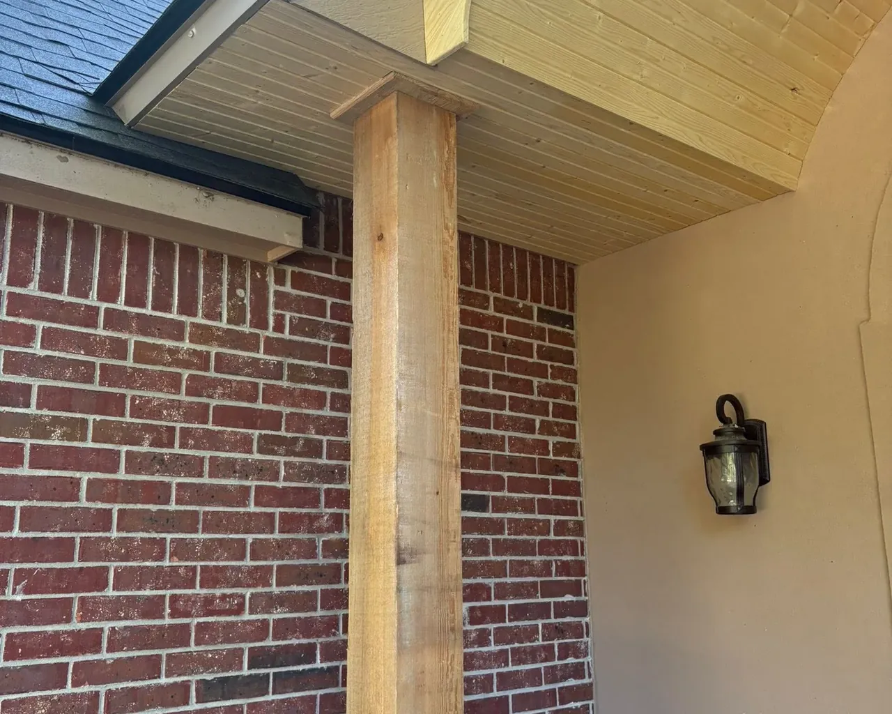 Wood porch soffit over brick wall with timber column, C&A Roofing & Construction
