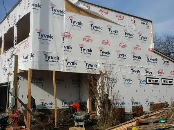 Multi-story house framing wrapped in Tyvek, C&A Roofing & Construction