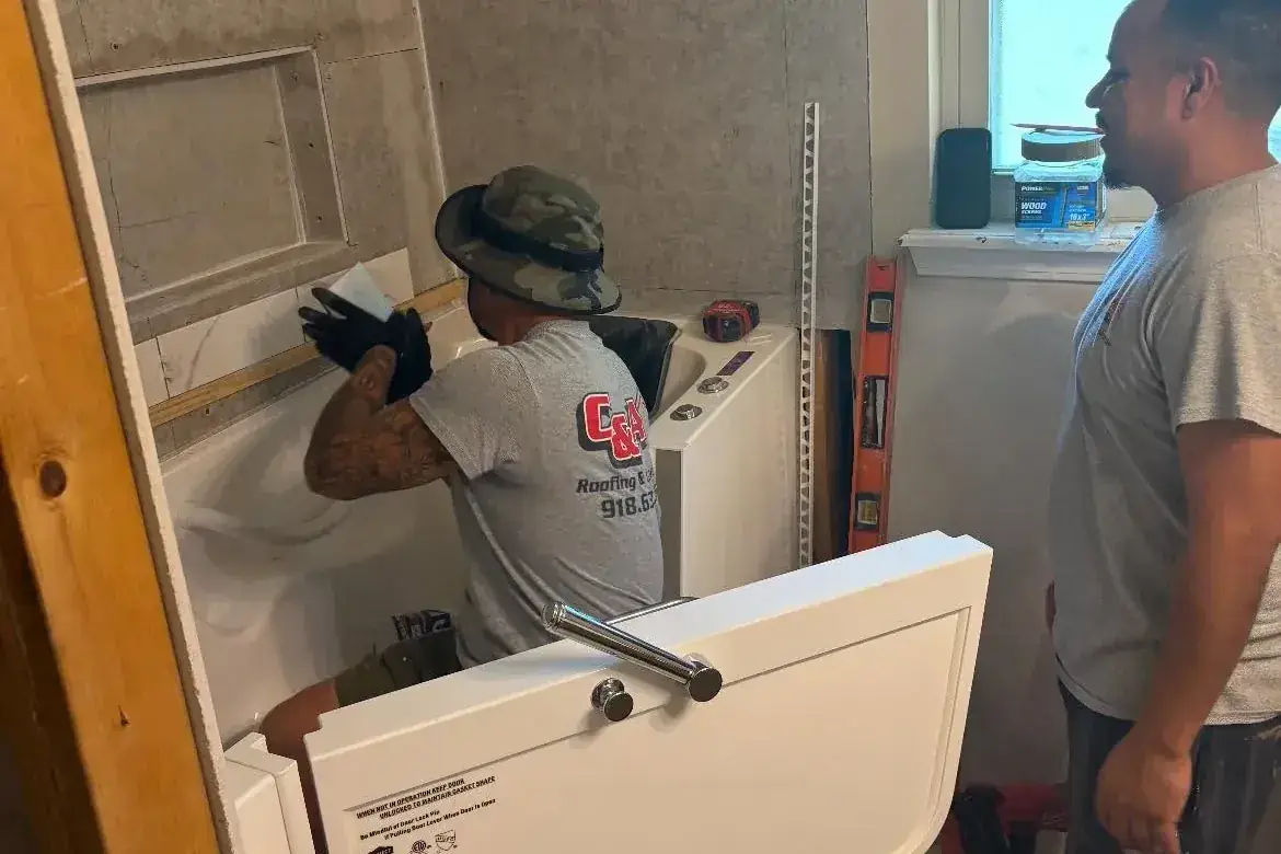 Two workers installing an accessible walk-in bathtub, C&A Roofing & Construction
