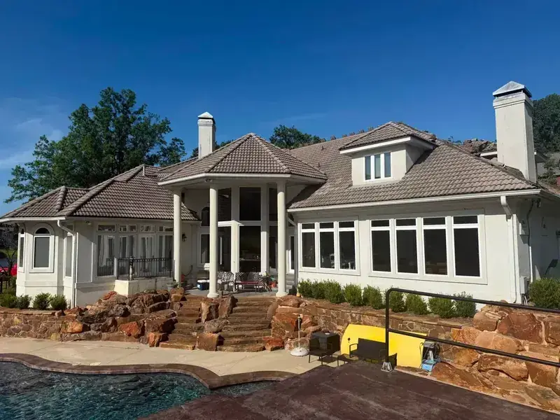 Large house with shingle roof and construction materials, C&A Roofing & Construction