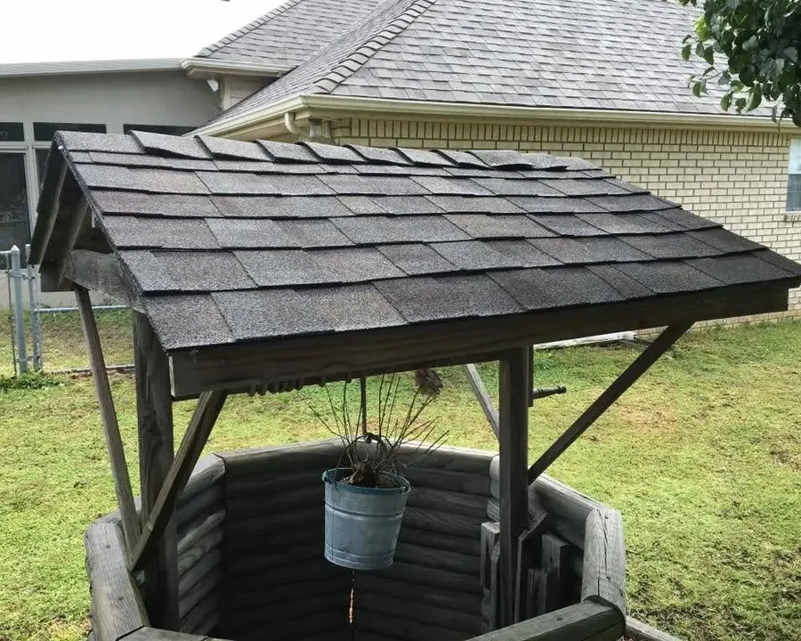 Backyard wishing well with dark shingle roof, C&A Roofing & Construction