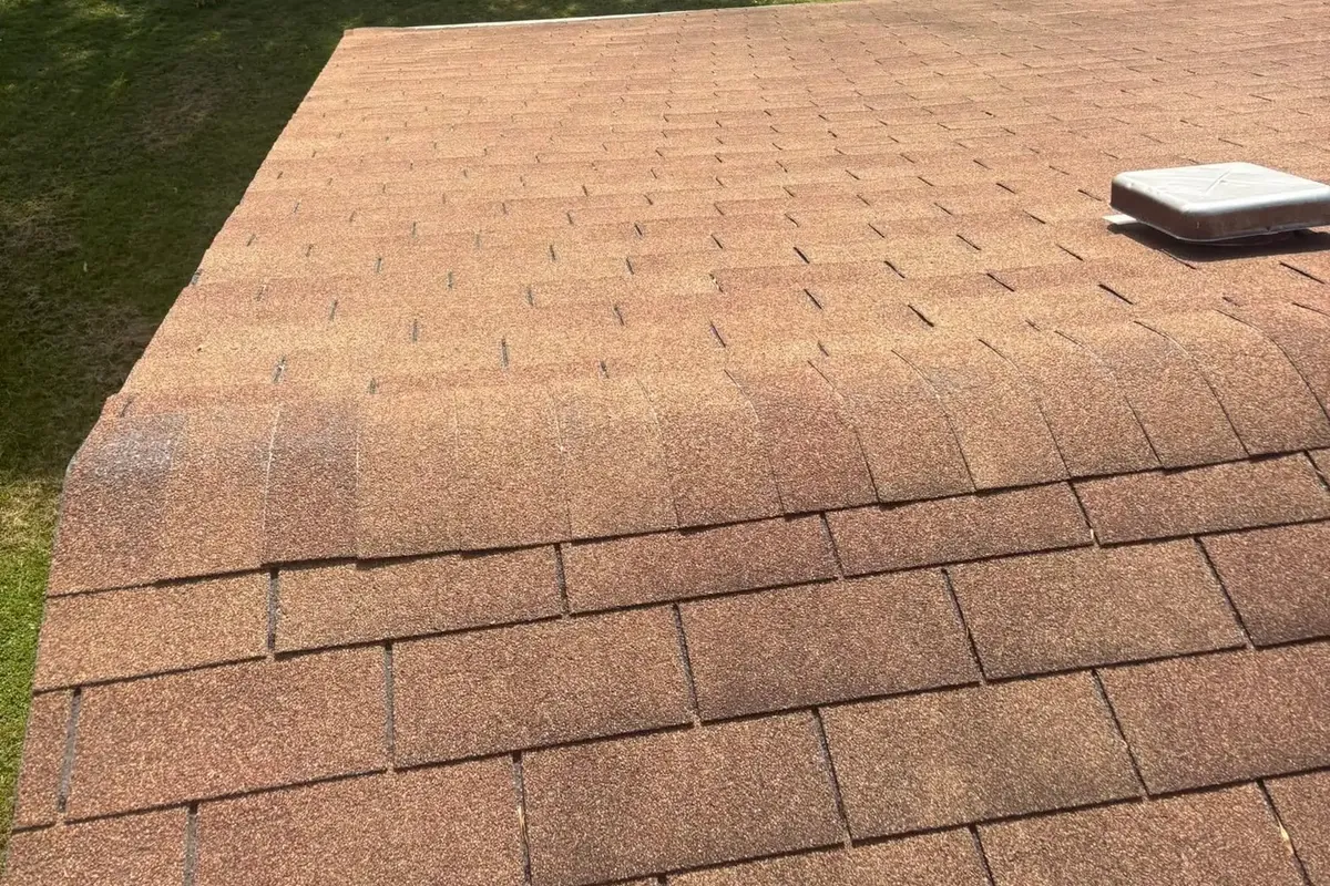 Brown shingle roof edge with yard beyond, C&A Roofing & Construction