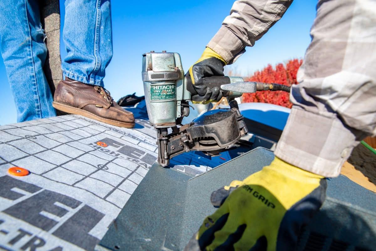 Professional roofing installation with pneumatic nail gun